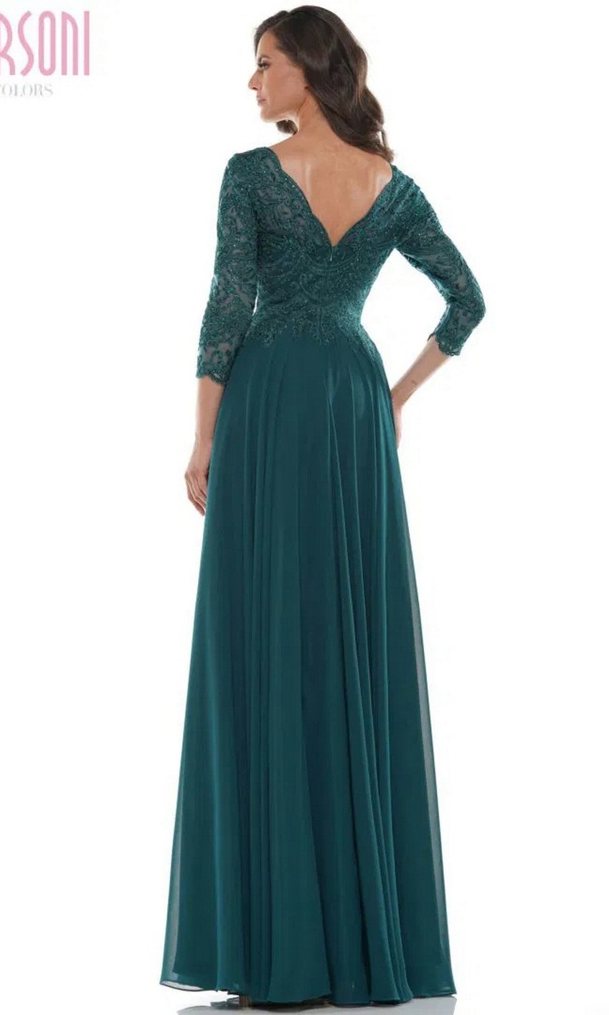 A woman models the Marsoni M238SL, a long formal dress with a beaded bodice, teal chiffon A-line skirt, lace sleeves, and V-shaped back, standing and facing away from the camera.